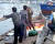 지난 15일 북한 선원 4명이 탄 어선의 어민들이 현장에 출동한 해양경찰에 조사 받는 영상이 공개됐다. 사진은 당시 삼척항 부두에 정박한 북한어선과 어민이 경찰에 조사받는 모습. [독자제공=뉴스1]