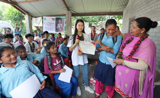 16일 헤퍼 장학금수여식이 열린 네팔 치트완 틴도반학교에 임수빈 학생이 네팔 여학생에게 장학금을 전달한 후 기념사진을 찍고 있다. 최승식 기자