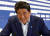 아베 신조 일본 총리가 지난달 22일 자민당 본부에서 열린 기자회견에서 질문을 받은 뒤 웃고 있다. [로이터=연합뉴스] 