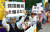 19일 오후 도쿄 나가다초 국회의사당 주변에서 열린 &#39;일한(한일)시민 연대하자&#39; 집회에서 한 참가자가 &#39;한국 적대시를 부추기지 말라&#39;는 손팻말을 든 채 구호를 외치고 있다. [연합뉴스]