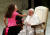 21일(현지시간) 바티칸에서 열린 일반알현에서 어린 소녀가 연단에 올라와 프란치스코 교황에게 손을 내밀고 있다. [로이터=연합뉴스]