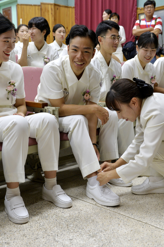 선배 간호장교가 제62기 2학년 한 남생도의 신발끈을 묶어주고 있다. 대전=프리랜서 김성태