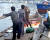 지난 6월 15일 삼척항 부두에 정박한 북한어선과 어민이 경찰에 조사받는 모습. [뉴스1]