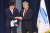 김수현 전 대통령비서실 정책실장(오른쪽)이 지난 6월 21일 신임 김상조 실장과 손을 잡고 인사를 나누고 있다. [중앙포토]