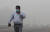 지난 3일 짙은 스모그가 낀 인도 뉴델리 거리를 마스크를 쓴 시민이 걷고 있다. [로이터=연합]