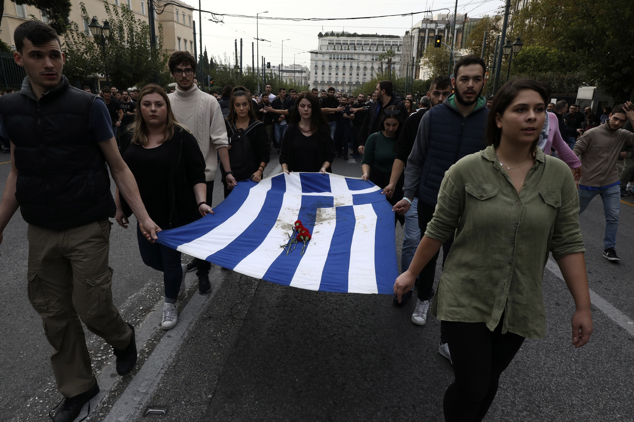 그리스 대학생들이 피묻은 그리스 깃발을 들고 행진하고 있다. [AP=연합뉴스]
