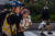 지난 10월 말 홍콩 침사추이 시내에서 한 홍콩 시민이 경찰이 쏜 최루가스로 부터 아이를 보호하기 위해 자신이 쓰던 방독마스크를 아이에게 씌워주고 있다.[AFP=연합뉴스]