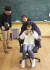 정하민 학생기자가 스마트폰으로 촬영하고, 정아인 학생기자가 그가 앉은 의자를 뒤에서 밀고 있다. 인물의 이동 장면을 흔들림 없이 촬영할 수 있는 방법이다. 