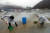 겨울비가 내린 7일 강원 화천군 산천어축제장에서 공무원들이 얼음낚시터 행사장으로 흘러 들어가는 물을 퍼내고 있다. [연합뉴스]