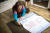 서 할머니가 폐현수막으로 만든 옷본을 이용해 재단하고 있다. 장진영 기자