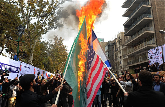 2015년 이란 수도 테헤란 시내에서 시위대가 미국과 이스라엘, 그리고 사우디아라비아의 국기를 불태우고 있다. 국기 훼손은 모욕을 부르고, 모욕은 증오와 원한으로 이어지게 마련이다. [위키피디아]