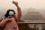 〈중국〉 26일(현지시간) 중국 베이징에서 한 관광객이 코로나바이러스 확산으로 폐쇄된 자금성을 배경으로 사진을 찍고 있다. [UPI=연합뉴스]