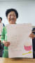 소룡동주민센터에서 문해 교육을 받는 김순애(82)씨가 자작시 '식은 죽 먹기'를 적은 도화지를 들어 보이고 있다. [사진 군산시]