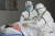 1일 중국 안후이성 푸양의 한 병원에서 보호복을 입은 의료진이 신종 코로나바이러스 감염증 확진환자를 격리 병동으로 옮기고 있다. [AP=연합뉴스]