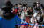 신종코로나바이러스감염증(코로나19)이 확산되는 가운데 23일 오후 서울 종로구 경복궁에서 마스크를 쓴 관광객이 수문장 교대 의식을 보고 있다. [연합뉴스]