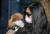지난달 21일 중국 광저우에서 마스크를 쓴 주인이 강아지 마스크를 한 애완견을 안고 거리를 걷고 있다.[뉴시스]