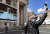 8일 성 베드로 광장에서 마스크와 비닐장갑을 낀 한 관광객이 교황 화면을 배경으로 기념사진을 찍고 있다. [EPA=연합뉴스]