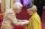 엘리자베스 2세 영국 여왕이 지난 3일 런던 버킹엄궁에서 열린 훈장·기사작위 수여식에서 배우 웬디 크레이그에게 장갑 낀 손으로 훈장을 달아주고 있다.［AP=연합뉴스]