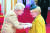 셀럽들의 코로나 대응이 화제다. 왼쪽부터 엘리자베스 2세 여왕이 장갑 끼고 작위를 수여하는 모습. [AP=연합뉴스]