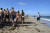 한 남성(오른쪽)이 17일(현지시간) 봄방학을 맞아 미국 플로리다 폼파노 해변을 찾은 학생들 옆을 지나고 있다. [AP=연합뉴스]
