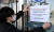 20일 오전 인천시 연수구 송도국제도시 G타워 에서 직원이 건물 폐쇄 안내문을 붙이고 있다. [뉴시스]