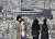 지난 24일 일본 도쿄의 한 전망대에서 마스크를 쓴 관광객들이 도쿄올림픽 메인스타디움을 바라보고 있다. 일본 정부가 이날 밤 도쿄올림픽 연기를 전격 발표한 가운데 25일 도쿄에선 하루 최다 신종 코로나 확진자가 발생했다.[EPA=연합뉴스] 