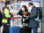 24일 인천국제공항 제2터미널에서 영국 런던발 여객기를 타고 입국한 외국인 승객들이 신종 코로나바이러스 감염증(코로나19) 진단 검사를 받기 전 경찰 관계자에게 안내를 받고 있다. [뉴스1]