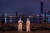 지난 25일 중국 우한 한커우(漢口) 해변 공원에 방호복을 입은 두 사람이 서있다. 연합뉴스