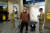 마스크와 장갑을 낀 남성이 30일 미국 로드아일랜드의 한 기차역에서 주방위군 앞을 지나고 있다. 주 방위군은 로드아일랜드주에 도착하는 모든 여행객은 14일간 자가 격리 해야 한다고 안내하고 있다. [AFP=연합뉴스]