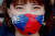 지난달 30일 대만 타오위안에서 한 여성이 국기(청천백일기)가 그려진 마스크를 쓰고 있다. 코로나 대응 모범국인 대만은 해외 의료지원의 일환으로 마스크 1000만개를 각국에 기증하기로 했다. [EPA=연합뉴스] 