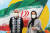 마스크를 쓴 이란인들이 이란 국기가 그려진 테헤란의 벽화 앞에서 포즈를 취하고 있다.［AFP=연합뉴스］