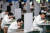 중국 우한의 한 자동차공장 직원들이 거리를 두고, 칸막이로 앞을 가린 채 점심을 먹고 있다. [AFP=연합뉴스] 