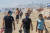 마스크를 쓴 미국 시민들이 25일 캘리포니아 헌팅턴 비치를 걷고 있다. AFP=연합뉴스