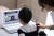 지난달 20일 오전 서울 용산구의 한 가정에서 용산초등학교 1학년에 입학한 신입생 어린이가 엄마와 함께 노트북 화면을 통해 온라인 입학식을 하고 있다. 연합뉴스