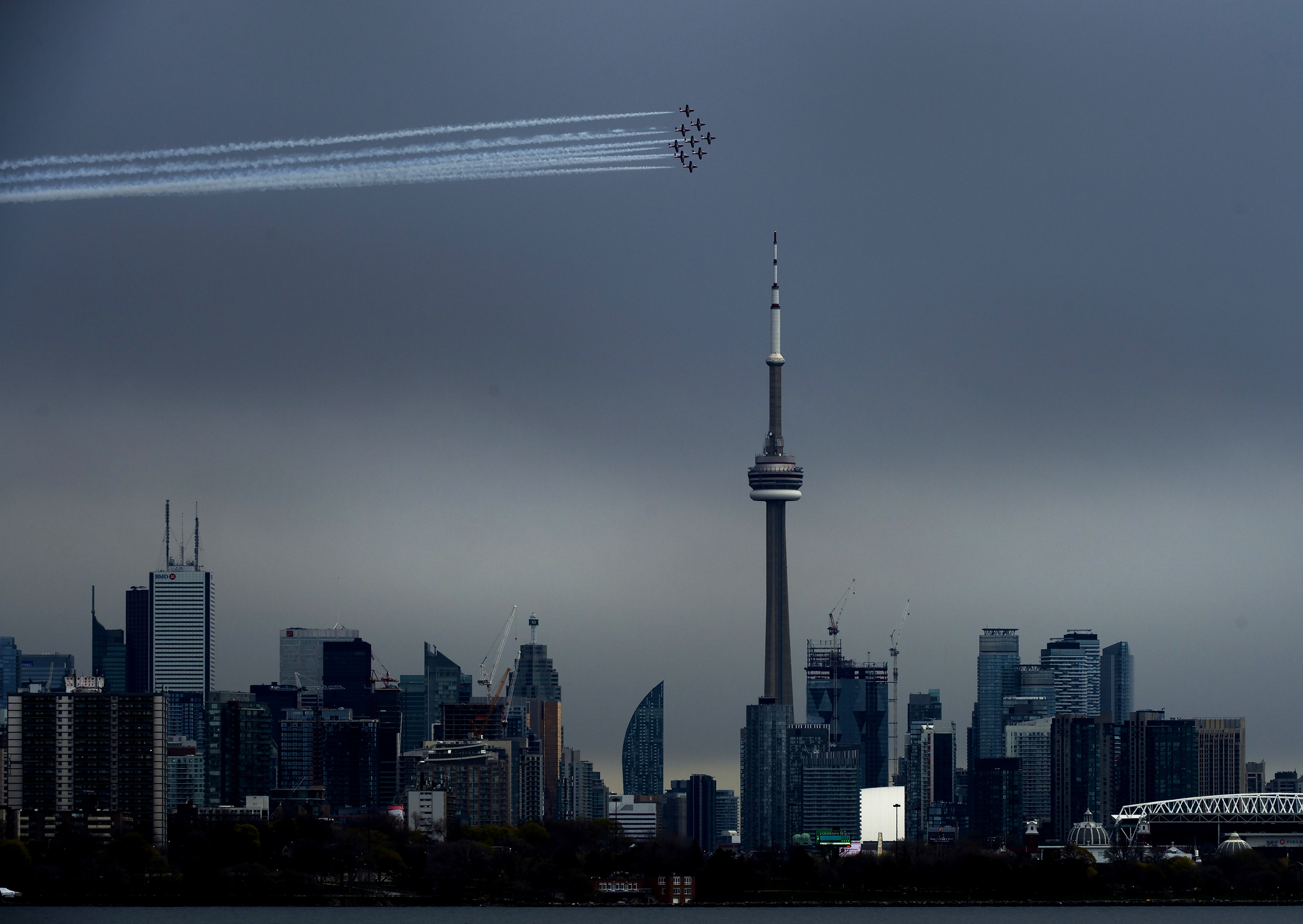 캐나다 공군 특수비행팀 스노우버드가 지난 10일 캐나다 토론토에서 코로나19와 분투하고 있는 국민들을 응원하기 위해 CN타워를 돌며 멋진 비행을 선보이고 있다. [AP=연합뉴스]