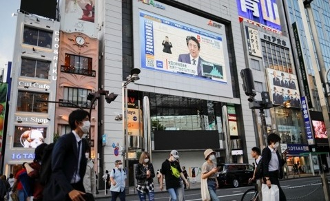 아베 신조 일본 총리의 신종 코로나바이러스 감염증(코로나19) 대응 관련 기자회견 모습이 지난 14일 도쿄 신주쿠의 한 건물에 설치된 대형 스크린을 통해 생중계되고 있다. 로이터=연합뉴스