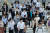 일본 도쿄에서 코로나19 긴급사태가 해제된 다음 날인 26일, 마스크를 쓴 시민들이 도쿄 시내를 지나고 있다. [AFP=연합뉴스]