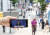 28일 오전 비교적 한산한 서울 명동 거리에서 취재진이 스마트폰을 들고 유튜브로 중계되는 '통화정책방향 이주열 한국은행 총재 기자간담회'를 선보이고 있다. 연합뉴스