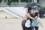 갑작스럽게 소나기가 내린 28일 오전 서울 종로구 한 초등학교에서 학교보안관이 우산을 미처 준비하지 못한 아이들에게 우산을 씌워주며 교실로 함께 이동하고 있다. 연합뉴스