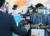 탑승객 마스크 착용 의무화 조치가 시행된 27일 오후 인천국제공항에서 관계자가 마스크를 쓴 승객들의 체온을 측정하고 있다. 연합뉴스