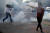 지난달 31일(현지시간) 최루 가스가 터진 미국 미네소타주 시위 현장 속에서 카메라를 든 취재진이 서둘러 이동하고 있다. 로이터=연합뉴스