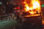 워싱턴DC의 한 시민이 지난달 30일(현지시간) 불타고 있는 자동차를 향해 플라스틱 물체를 던지고 있다. [AFP=연합뉴스]