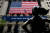 미국 뉴욕 월스트리트에 있는 증권거래소 앞 '용감한 소녀'상. 코로나19 시대를 함께 이겨내자는 플래카드가 대형 성조기와 함께 붙어있다. AFP=연합뉴스