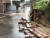 지난 10일 호우경보가 내린 부산 수영구의 한 일방통행로 옆 담장이 폭우로 무너져 토사가 흘러내리고 있다. 뉴스1
