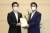 지난 14일 요시무라 히로후미(왼쪽) 오사카부 지사가 아베 신조 총리를 만나 신종 코로나바이러스 감염증 대책과 관련한 요청서를 전달한 뒤 사진을 찍고 있다. [지지통신] 