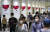 지난 15일 도쿄올림픽 관련 홍보물이 전시된 도쿄 도심의 한 통로를 마스크를 쓴 시민들이 지나가고 있다. [EPA=연합뉴스] 