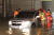 23일 인천 중구 운북동의 한 도로에서 차량 하부가 집중호우로 인해 물에 잠겨 소방대원들이 구조작업을 벌이고 있다. 연합뉴스