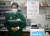 코로나19가 확산되던 지난 4월 일본 도쿄의 한 편의점 접수대에 방역 차원에서 비닐 칸막이가 쳐져 있다. 그 뒤에 마스크를 쓴 점원이 대기 중이다. [로이터=연합뉴스]