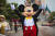 프랑스 파리 인근의 디즈니 파리 테마파크가 재개장한 지난 15일 디즈니의 대표 캐릭터 미키마우스 탈을 쓴 직원이 퍼레이드 중 포즈를 취하고 있다. [EPA=연합뉴스]