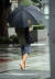 1일 정오경 서울 시내에 강한 빗줄기가 쏟아지자 한 시민이 신발을 벗고 맨발로 이동하고 있다. 연합뉴스